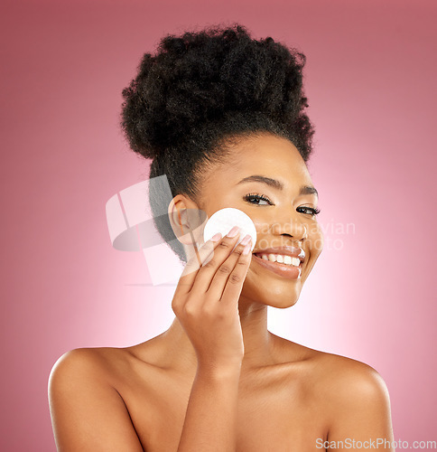 Image of Black woman, cotton pad and skincare with makeup, portrait and facial on a studio background. Female person, face and happy model with cosmetics, aesthetic and cleaning with patches, shine and glow
