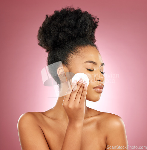 Image of Black woman, cotton pad and dermatology with makeup, facial and salon treatment on a studio background. Female person, shine or model with cosmetic tools, glow and cleaning with patches and aesthetic
