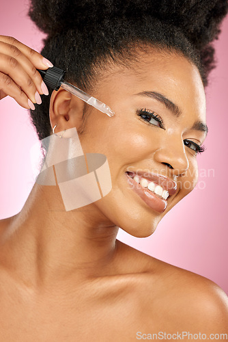 Image of Black woman, portrait and serum for face in studio, aesthetic skincare and dermatology on pink background. Happy female model, facial cosmetics and dropper of hyaluronic acid, oil and beauty collagen