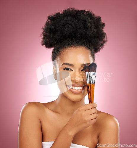 Image of Portrait, makeup and black woman with brushes, skincare and dermatology against a pink studio background. Female person, aesthetic or model with cosmetic tools, natural beauty or shine with self care