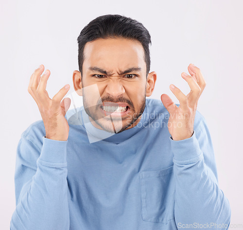 Image of Mental health, anger and mad with a frustrated man in studio on a gray background feeling stress. Face, psychology and emotions with a young male person looking annoyed while gritting his teeth