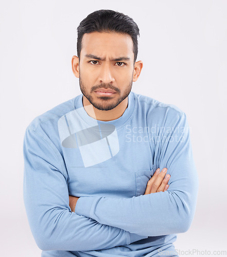 Image of Portrait, angry and man with arms crossed, frustrated and upset guy against a white studio background. Face, male person and model with anger, expression and frustration with emotion and conflict