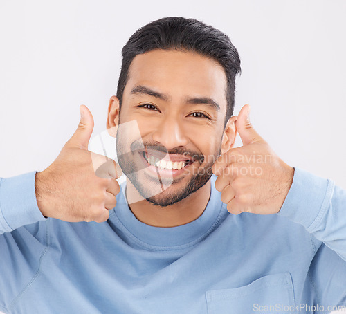 Image of Thumbs up, portrait and asian man happy in studio with hand, sign and thank you on grey background. Smile, face and Japanese male with finger emoji for yes, vote or positive review, feedback or agree