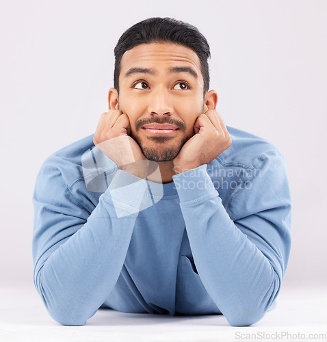 Image of Memory, thinking and young man in a studio resting on his arms with a problem solving facial expression. Happy, smile and Indian male model with question or dream face isolated by a white background.