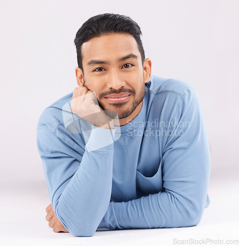 Image of Fashion, portrait and confident man on the floor in studio isolated on a white background. Face, style and young Asian model in casual clothes, trendy aesthetic and relax on the ground in Cambodia