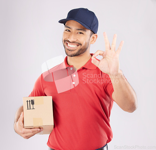 Image of Courier man, ok sign and studio portrait with box, delivery, opinion or good service by white background. Supply chain manager, happy or review with like icon, emoji and hand with cardboard package