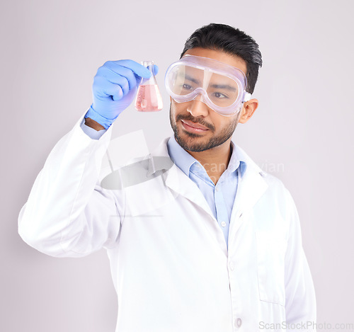 Image of Scientist man, studio and beaker with goggles, thinking or analysis for focus by white background. Asian science expert, glass container and chemistry innovation with idea, ppe or study at pharma job
