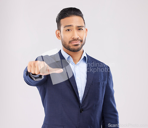 Image of Review, portrait and a marketing businessman with a hand on a studio background for feedback. Choice, sign language and an Asian employee with a thumb gesture for a decision isolated on a backdrop