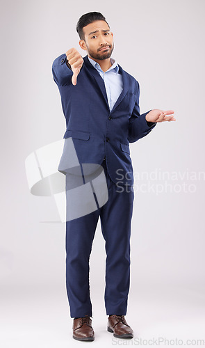 Image of Portrait, thumbs down and confused business man with negative fail sign, no opinion or decision disagreement. Bad studio service, reject vote gesture or professional person rating on white background