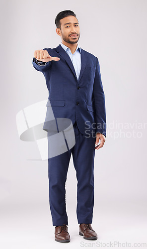 Image of Neutral review, portrait and businessman in suit on a studio background for marketing or feedback. Choice, sign language and an Asian lawyer with a thumb gesture for a decision isolated on a backdrop