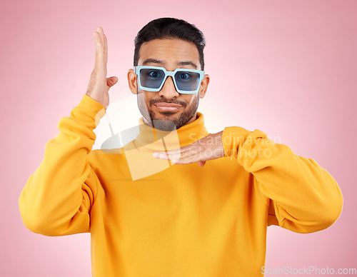 Image of Man, funny dancing and sunglasses for portrait, studio and smile, hands and clothes for aesthetic by pink background. Asian gen z student, happy and color lens for fashion, dance and frame for face