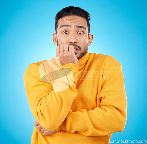 Image of Anxiety, portrait and asian man biting nails in studio with stress, suspense or crisis on blue background. Face, worry and nervous male with emoji reaction to news, gossip or did you know drama