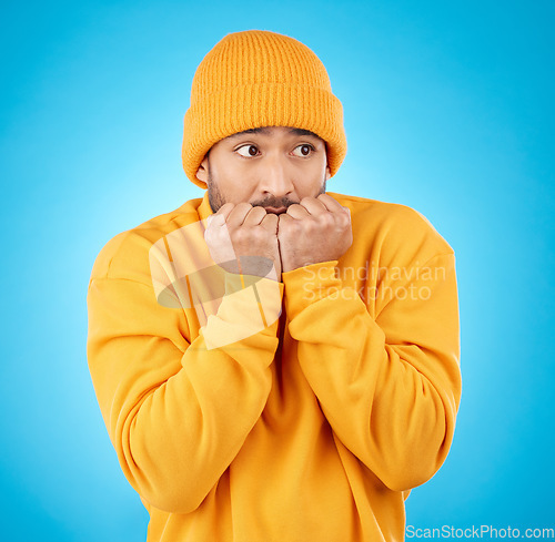 Image of Nervous, anxiety and asian man biting nails in studio with terror, fear and scared for secret phobia on blue background. Stress, suspense and male person waiting for horror, danger alarm or bad news