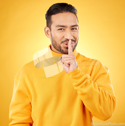 Image of Secret, man and finger on lips for gossip, confidential information or sign with hand for whisper in studio or yellow background. Announcement, emoji or person for communication or silence of sound