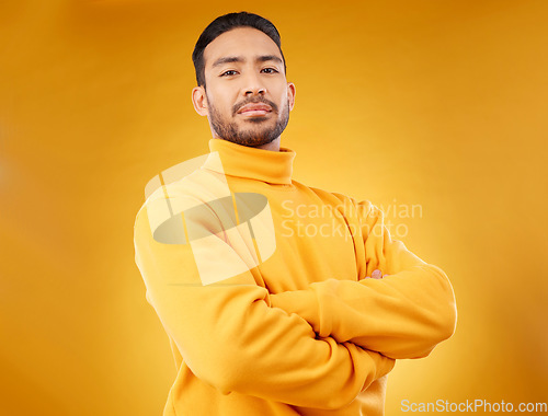 Image of Fashion, winter and portrait of man with arms crossed for style, cool and trendy aesthetic. Yellow, handsome and Asian person or model with confidence, pride and power on a studio background