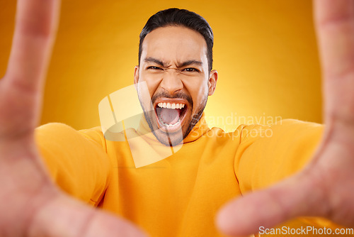 Image of Shouting, portrait and selfie of angry man in studio isolated on a yellow background. Face, screaming and Asian person taking profile picture for memory in anger, frustrated or stress on social media