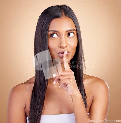 Image of Beauty, secret and woman with finger on mouth for skincare, wellness and cosmetics on brown background. Natural makeup silence, dermatology and smile on face, model with skin glow facial in studio.