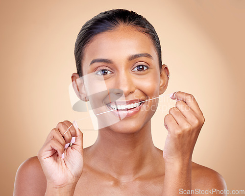 Image of Woman, mouth and flossing in studio portrait with smile, cleaning or teeth whitening by brown background. Girl, model and happy for dentistry product, string or self care for tooth, beauty or health