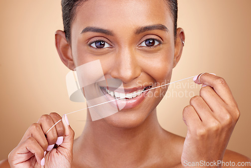 Image of Woman, dental floss and studio portrait with smile, cleaning and teeth whitening by brown background. Girl, model and happy with dentistry product, string or self care for cosmetics, beauty or health