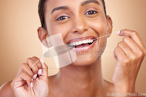 Image of Woman, tooth and floss in studio portrait with smile, cleaning or self care by brown background. Girl, model and happy for dentistry product, string or teeth whitening for cosmetics, beauty or health