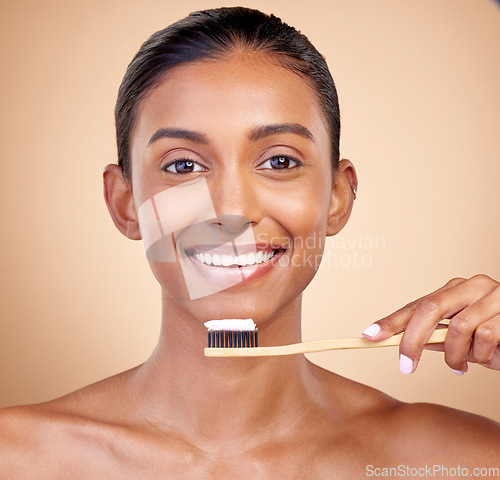 Image of Woman, wood toothbrush and studio portrait for smile, cleaning and teeth whitening by brown background. Girl, model and happy with bamboo dentistry product, self care and cosmetic beauty with health