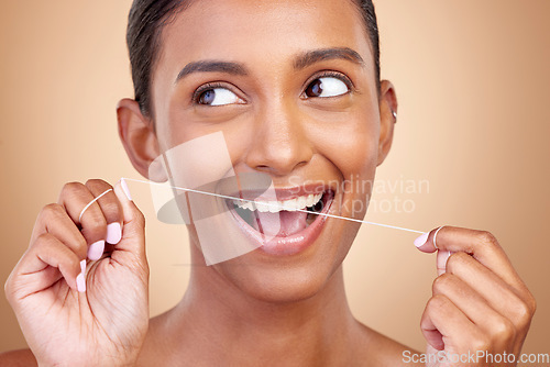 Image of Woman, dental floss and studio for thinking, smile and cleaning for teeth whitening by brown background. Girl, model or happy for dentistry product, ideas or self care for cosmetic, beauty or health