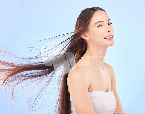 Image of Portrait, hair and beauty with a model woman in studio on a blue background for shampoo or keratin treatment. Spa, salon or hairdresser with an attractive young female person posing for haircare