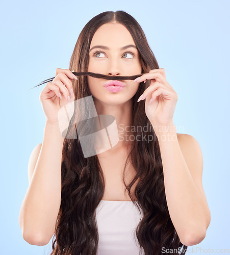 Image of Hair, moustache and woman in studio for beauty, salon aesthetic or healthy shampoo on blue background. Haircare, face and funny female model with strand of natural waves, texture or keratin cosmetics