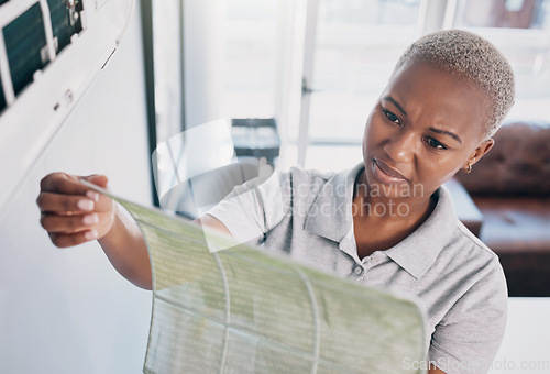 Image of Dirty, cleaning and a black woman with a wall cover for maintenance, building or home renovation. Dust, construction and an African girl or cleaner with a trash, waste or garbage problem in a house