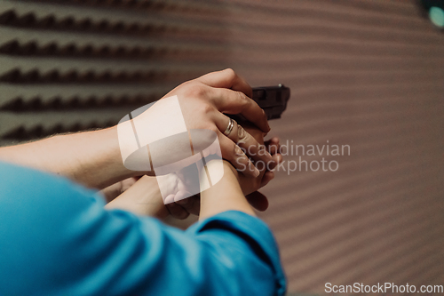 Image of The trainer explaining to the man how to use the gun. Training in the shooting range