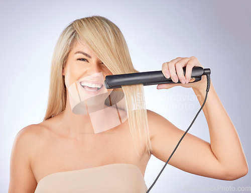 Image of Portrait, happy hair care and woman with straightener for a professional salon treatment. Smile, health and an excited young model or girl with an iron from hairdresser for a hairstyle on a backdrop