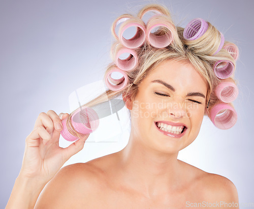 Image of Woman, hair care and pain with roller for beauty in studio isolated on a white background. Happy, curlers and model with hairstyle for aesthetic, cosmetics and salon treatment for natural growth.