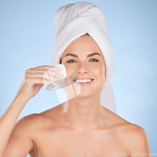 Image of Bathroom, studio portrait and happy woman with cotton pad for skincare cleaning, self care or foundation. Beauty, face or person with hygiene, wellness and makeup removal product on blue background