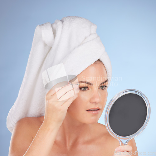 Image of Beauty, woman and mirror with tweezers for eyebrow in studio, blue background or aesthetic change. Face of female model, epilation tools and hair removal for grooming brows, facial skincare or shower