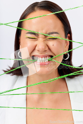 Image of Crazy, biting rope and a woman on a white background with mental health problem or funny. Stress, young and a model or girl with string for escape or trapped while isolated on a studio backdrop