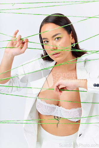 Image of Art, fashion and strings with portrait of Asian woman in studio for creative makeup and cosmetics. Abstract, cotton and texture with face of model on white background for designer, trendy and textile