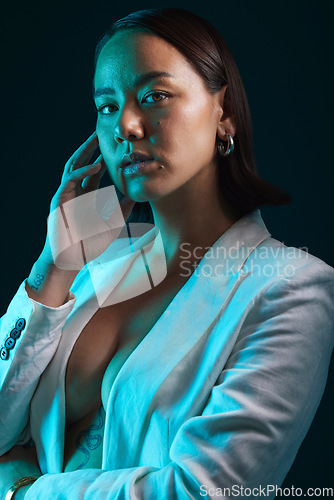 Image of Neon, beauty and portrait of woman in studio with blue light for stylish, classy or formal fashion. Style, cosmetic and young Asian female model with makeup and fancy blazer by dark black background.