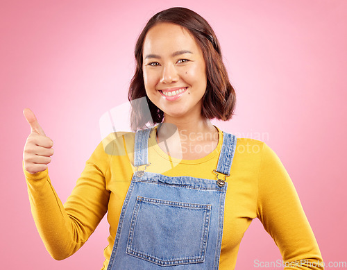 Image of Happy, thumbs up and yes with portrait of woman in studio for support, agreement and motivation. Winner, emoji and success with person on pink background for achievement, thank you and vote sign