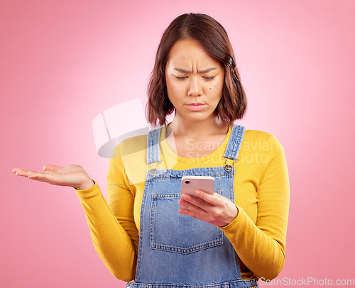Image of Reading, studio or Asian woman with cellphone problem, bad news and stress over mistake, crisis or social media. Spam notification, doubt or person confused over smartphone scam on pink background
