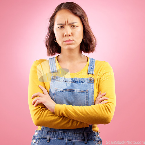 Image of Portrait, frown and angry asian woman with arms crossed in studio and defensive body language on pink background. Wtf, face and frustrated Japanese female disappointed by news, fail or mood isolated