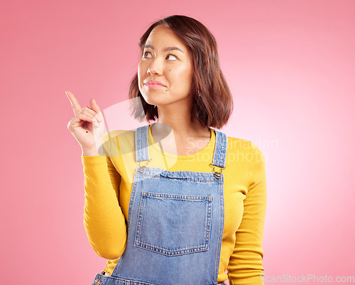 Image of Asian woman, smile and hand pointing to studio for news, announcement or coming soon deal on pink background. Finger, show and Japanese lady with timeline, checklist or sign up, promo or contact info