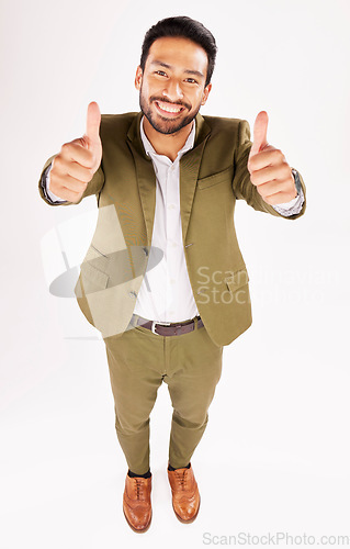 Image of Thumbs up, portrait and happy business man in studio, white background and trust of success from above. Asian worker, winner and like emoji for feedback, review and vote yes in agreement of support
