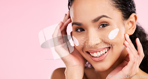 Image of Face, cream and beauty of a woman with skin care, dermatology and natural glow. Headshot of a young female aesthetic model with space for moisturizer, cosmetics or sunscreen on a pink background