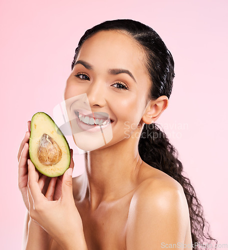 Image of Beauty, avocado and face of a happy woman with skin care, dermatology and natural glow. Portrait of female aesthetic model with fruit for moisturizer, cosmetics or diet nutrition on a pink background