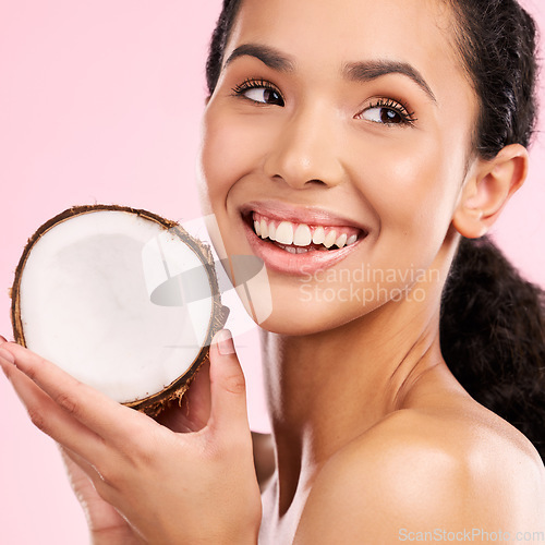 Image of Coconut, fruit and woman thinking of skincare, beauty or vegan cream on a pink, studio background. Young african person with natural product idea for dermatology and healthy cosmetics or oil benefits