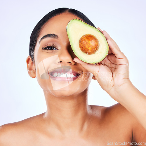 Image of Skincare, avocado and portrait of Indian woman in studio happy with detox, wellness or omega 3 treatment on grey background. Fruit, face and lady model smile for diy, mask or vitamin c facial beauty