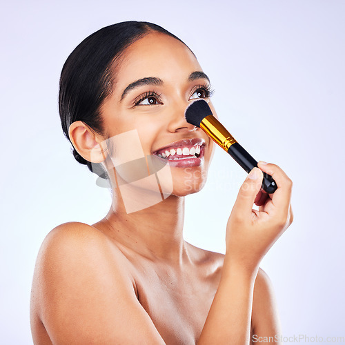 Image of Cosmetics, makeup brush and beauty of a happy woman in studio for skincare, self care and cosmetology. Skin glow, shine and wellness of a female model with facial application tools for foundation