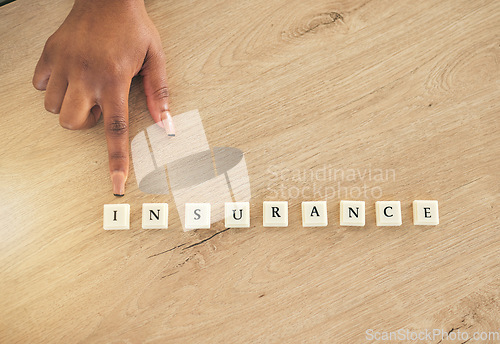 Image of Insurance, above and hand pointing at blocks or word on a wooden table as a emergency or accident message. Medical, policy and person showing letters of safety or security for future risk management