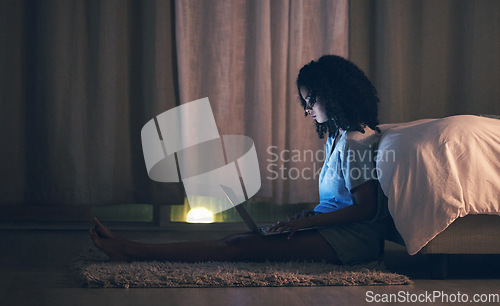 Image of Laptop, night and woman in her bedroom networking on the internet, social media or website. Technology, dark and female person doing research or browsing online with a computer in her apartment.