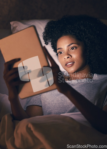 Image of Woman, tablet and bed with reading in dark room, typing and search for video, chat and social network. African girl, tech and relax in night, home and scroll for thinking, info and choice for movie